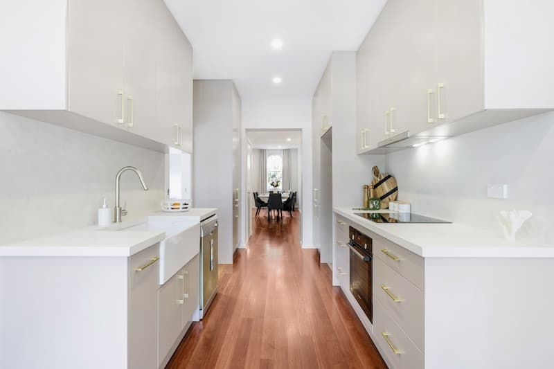 Discover an exquisite kitchen renovation featuring a modern design that combines functionality with style, crafted by Dura Group, the trusted Sydney-based building company. This sleek kitchen showcases high-quality cabinetry, state-of-the-art appliances, and elegant fixtures that enhance both aesthetics and practicality. The use of warm, hardwood flooring complements the bright, spacious layout, creating a welcoming environment for culinary creativity and family gatherings. Dura Group, led by the experienced Mark, brings 27 years of expertise in home transformations across the Sutherland Shire, Bayside, Inner West, Georges River, and Randwick regions. Specializing in home renovations, kitchen upgrades, and extensions, Dura Group partners with homeowners to deliver tailored building solutions, emphasizing budget-conscious planning, time efficiency, and transparent communication. Let this beautifully remodeled kitchen be the centerpiece of your dream home. Contact Dura Group today to begin your renovation journey and experience unmatched quality and service from a family-owned company that puts homeowners first.
