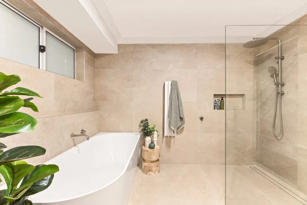 Modern bathroom with freestanding tub and walk-in shower by Dura Group