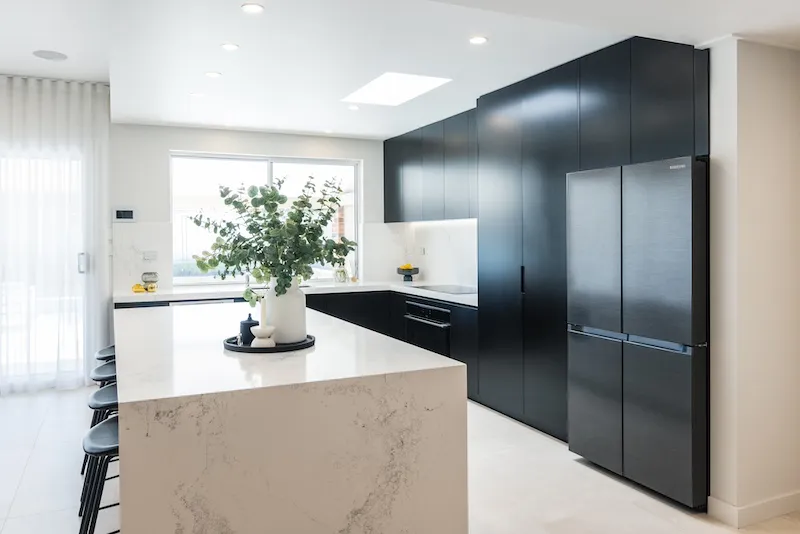 Experience the elegance of a modern kitchen renovation, expertly crafted by Dura Group, a leading Sydney-based building company. This sleek design features stylish black cabinetry and a spacious, marble-finish island, perfect for enhancing both functionality and aesthetics. At Dura Group, led by Managing Director Mark with over 27 years of construction experience, we specialize in kitchen upgrades that are time-efficient and budget-friendly. Operating in the Sutherland Shire, Bayside, Inner West, and surrounding areas, our team prioritizes homeowner satisfaction, ensuring open communication and high-quality builds. Trust us to transform your space with tailored solutions that reflect your unique style. Contact Dura Group today to start your dream kitchen project. Our expertise in home renovations guarantees a seamless experience, focused on trust, transparency, and excellence in every detail.