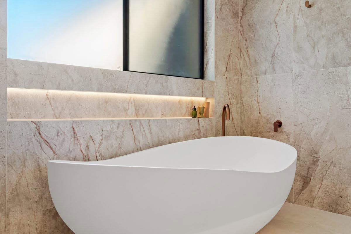 Bathroom renovation with freestanding bath and backlit stone nic