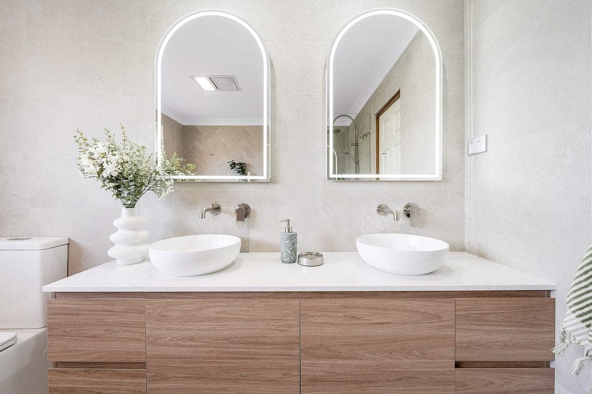 Bathroom renovation with twin arched mirrors and double vanity