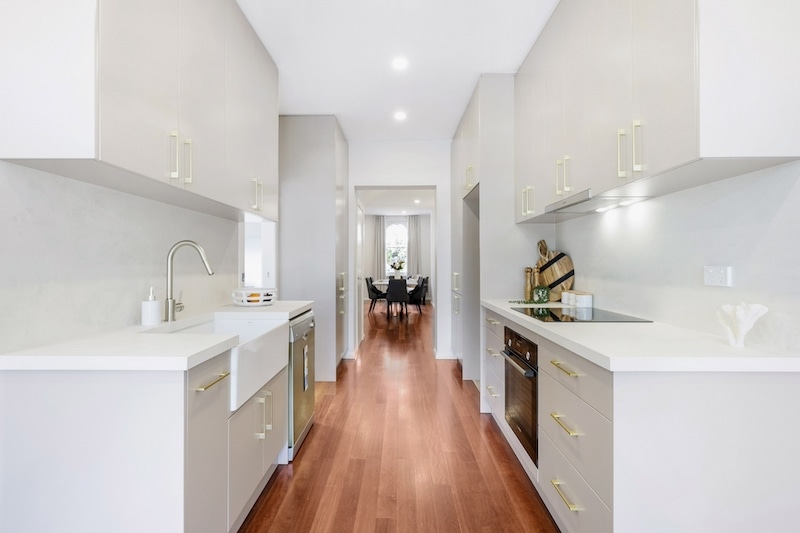 Discover an exquisite kitchen renovation featuring a modern design that combines functionality with style, crafted by Dura Group, the trusted Sydney-based building company. This sleek kitchen showcases high-quality cabinetry, state-of-the-art appliances, and elegant fixtures that enhance both aesthetics and practicality. The use of warm, hardwood flooring complements the bright, spacious layout, creating a welcoming environment for culinary creativity and family gatherings. Dura Group, led by the experienced Mark, brings 27 years of expertise in home transformations across the Sutherland Shire, Bayside, Inner West, Georges River, and Randwick regions. Specializing in home renovations, kitchen upgrades, and extensions, Dura Group partners with homeowners to deliver tailored building solutions, emphasizing budget-conscious planning, time efficiency, and transparent communication. Let this beautifully remodeled kitchen be the centerpiece of your dream home. Contact Dura Group today to begin your renovation journey and experience unmatched quality and service from a family-owned company that puts homeowners first.