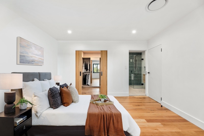 Discover the epitome of luxurious living with this beautifully designed master bedroom featuring an adjoining ensuite, crafted by Dura Group. As specialists in home renovations across Sydney, Dura Group brings over 27 years of expertise, ensuring impeccable build quality and homeowner-first service. This master suite showcases our commitment to creating tailored building solutions that reflect comfort and style. The room features a sophisticated color palette, plush bedding, and practical, elegant furnishings. The ensuite offers modern fixtures and a sleek design that promises both functionality and aesthetic appeal. With our focus on transparent communication, budget-conscious planning, and timely project delivery, Dura Group transforms your living spaces into dream havens. Experience the difference with our ground floor extensions, upper storey additions, kitchen upgrades, and bathroom and laundry renovations that breathe new life into your home. Let us partner with you in crafting spaces that enhance your lifestyle. Contact us today for a consultation and start your journey to enriched living with Dura Group. Act now; your dream home is just a call away!