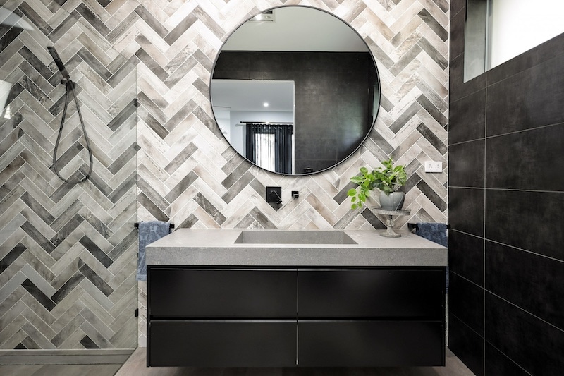 Transform your space with a stylish bathroom remodel featuring herringbone tiles. Enhance your home's value today with Dura Group. Contact us for a consultation!