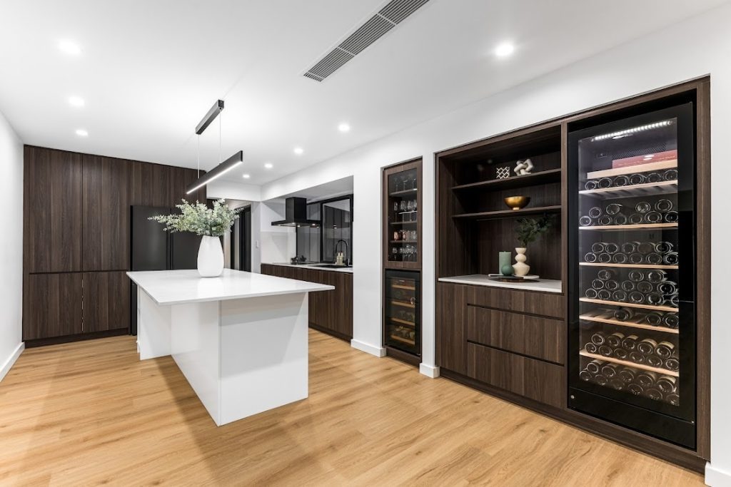 Contemporary kitchen with island, wine storage, and wood accents by Dura Group.