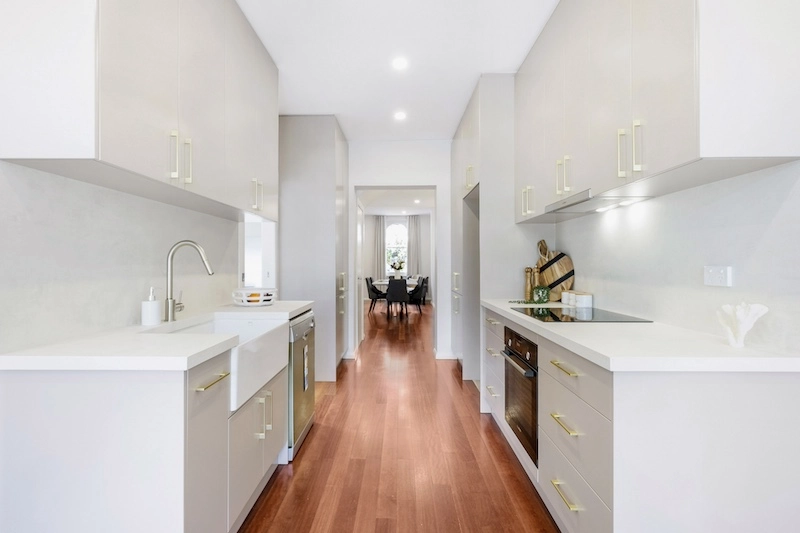 Discover an exquisite kitchen renovation featuring a modern design that combines functionality with style, crafted by Dura Group, the trusted Sydney-based building company. This sleek kitchen showcases high-quality cabinetry, state-of-the-art appliances, and elegant fixtures that enhance both aesthetics and practicality. The use of warm, hardwood flooring complements the bright, spacious layout, creating a welcoming environment for culinary creativity and family gatherings. Dura Group, led by the experienced Mark, brings 27 years of expertise in home transformations across the Sutherland Shire, Bayside, Inner West, Georges River, and Randwick regions. Specializing in home renovations, kitchen upgrades, and extensions, Dura Group partners with homeowners to deliver tailored building solutions, emphasizing budget-conscious planning, time efficiency, and transparent communication. Let this beautifully remodeled kitchen be the centerpiece of your dream home. Contact Dura Group today to begin your renovation journey and experience unmatched quality and service from a family-owned company that puts homeowners first.