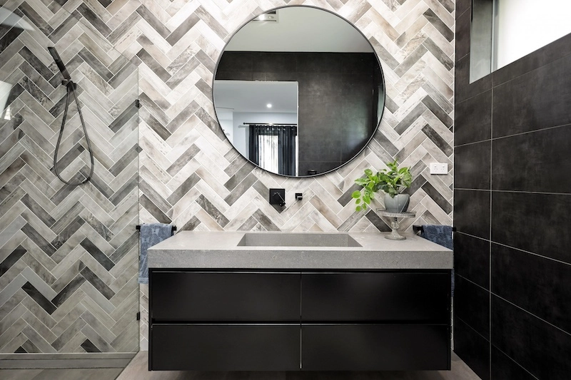 Transform your space with a stylish bathroom remodel featuring herringbone tiles. Enhance your home's value today with Dura Group. Contact us for a consultation!