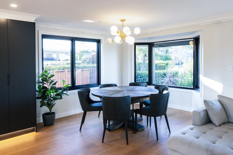 Experience modern elegance with this stunning dining room renovation by Dura Group, a leading Sydney-based construction company. Specializing in home upgrades across the Sutherland Shire, Bayside, and Inner West, Dura Group brings 27 years of expertise to every project. This beautifully designed space features sleek black furniture, a chic chandelier, and ample natural light, creating a welcoming environment for dining and socializing. At Dura Group, we prioritize time efficiency, budget-conscious planning, and open communication, ensuring your renovation is seamless and stress-free. Trust, transparency, and tailored building solutions are at the core of what we do, delivering high-quality results without compromise. Whether you're looking to update your dining area or transform your entire home, our team of experts guides you through every step, turning your vision into reality. Discover the difference with Dura Group and elevate your living space today. Contact us now to start your renovation journey with a company that puts homeowner satisfaction first.