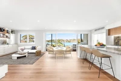 Experience luxury living with this open-plan kitchen and dining area featuring stunning waterfront views. Transform your home today with Dura Group.